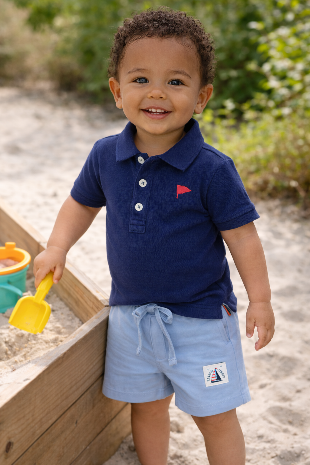 baby poloshirt navy met lichtblauw kort broekje bij zandbak